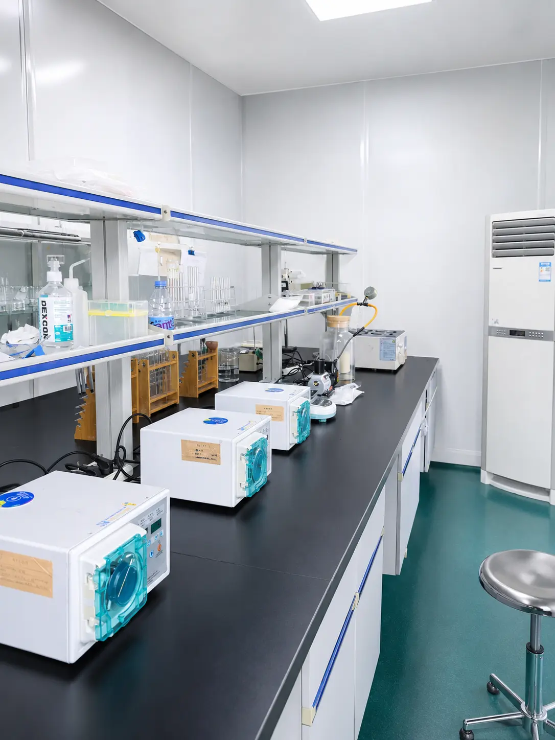 Workers in protective suits in a cleanroom environment.